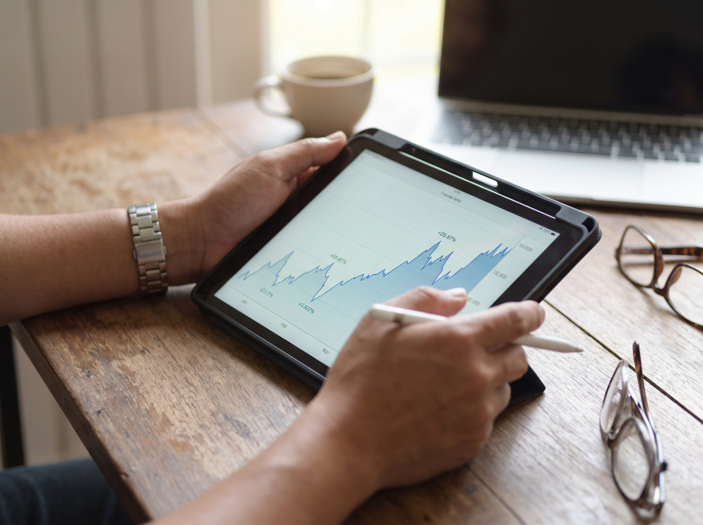 Tangan menyemak carta pertumbuhan portfolio di atas tablet